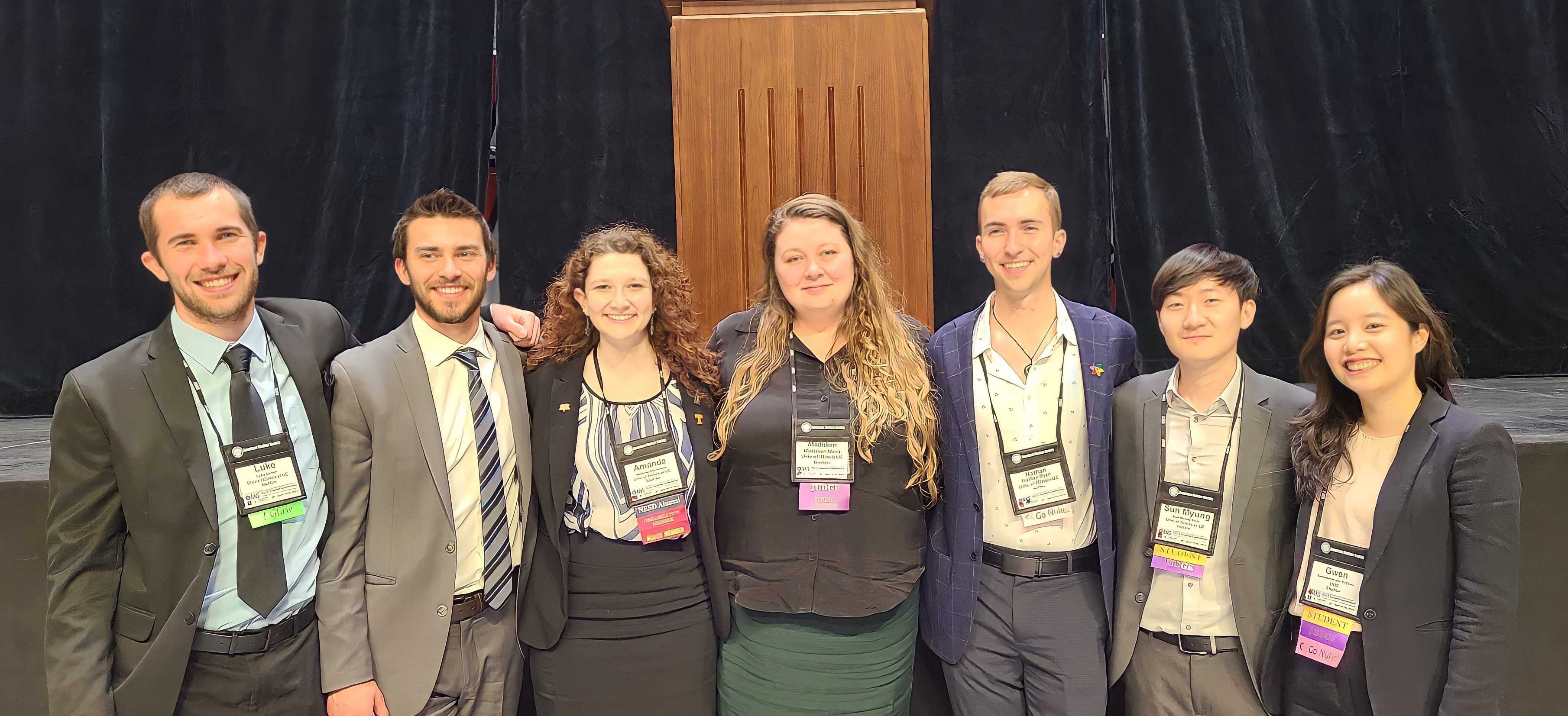 Some of the Advanced Reactors and Fuel Cycles group (including Nathan Ryan) standing in front of a stage at the 2022 ANS Student Conference.